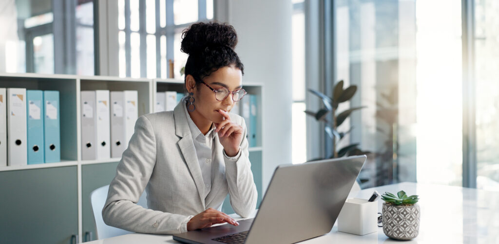 Thinking, laptop and typing business woman